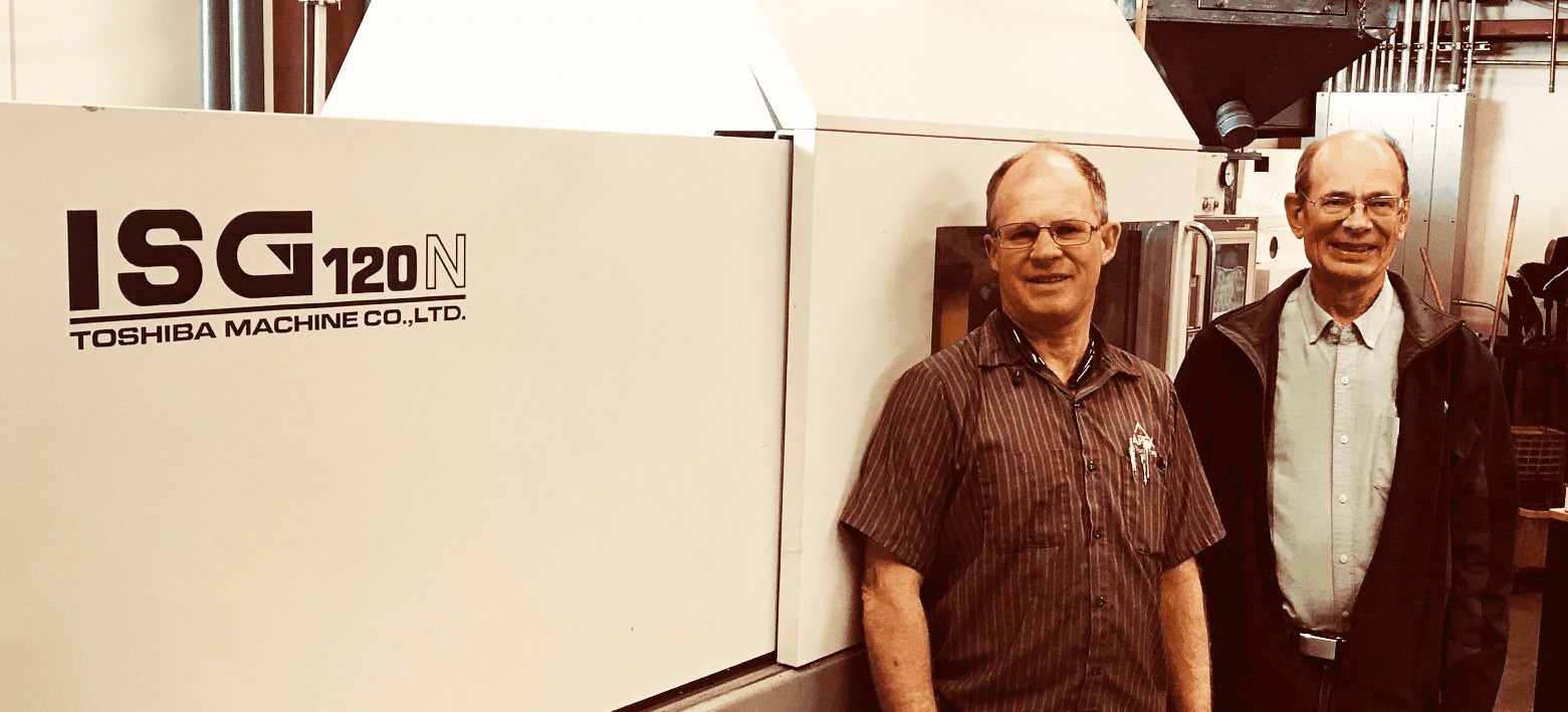 Two Men In Front Of Molding Machine